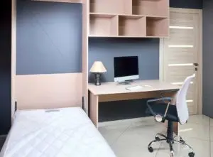 A small single Murpy bed next to a desk - Murphy bed cost and installation