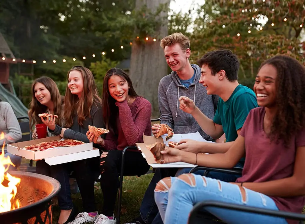 Teenagers enjoying a fire pit in the garden