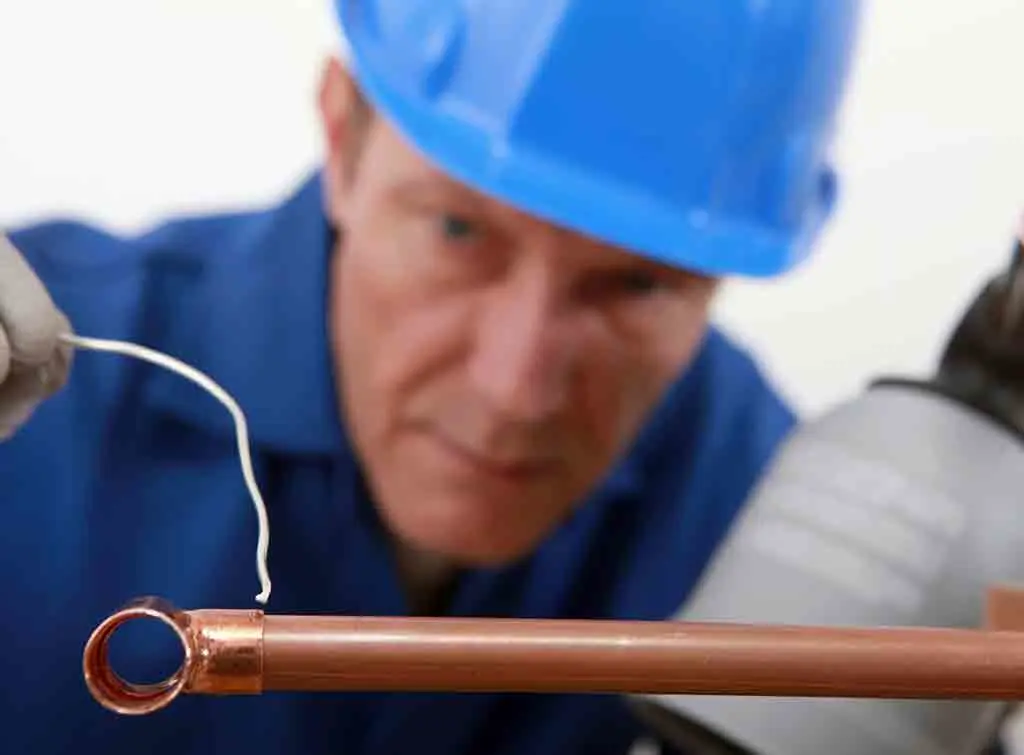 Man soldering copper pipes