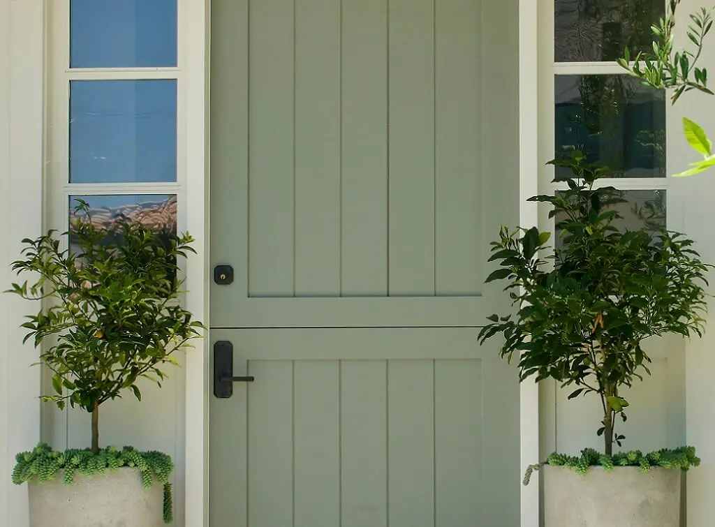 Solid, sage green composite stable door as a front entrance