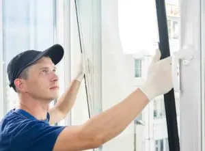 tradesperson fitting a double glazing unit