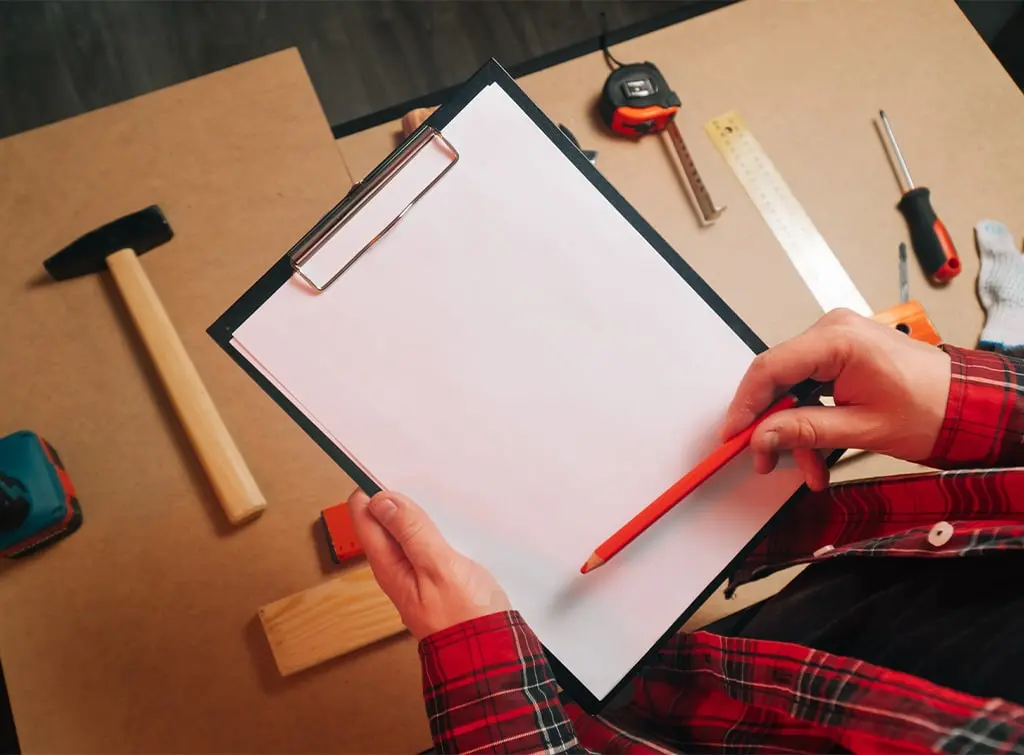 Tradesperson creating a business plan on white sheet of paper
