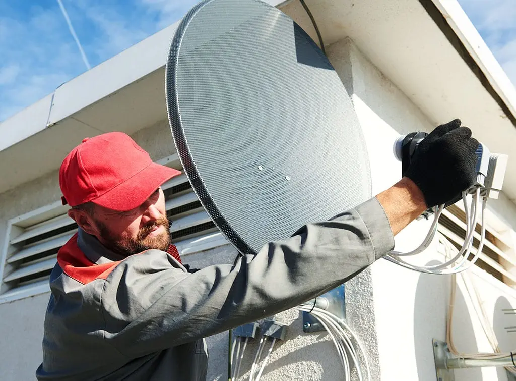 https://www.checkatrade.com/blog/wp-content/uploads/2021/09/tradesperson-installing-satellite-to-private-home.jpg