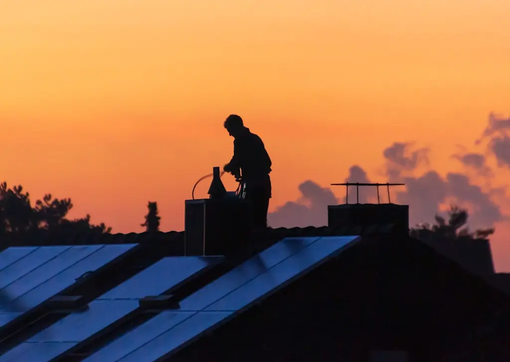 Chimney sweep working at sunset