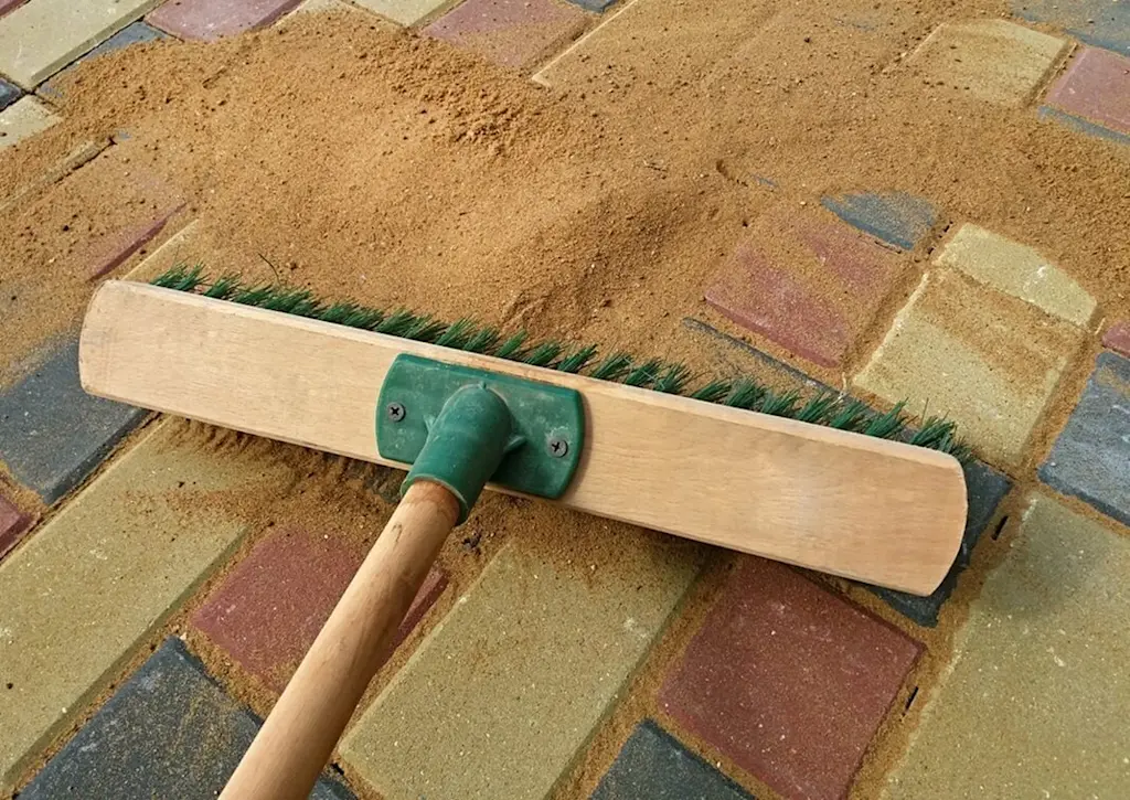 Sweeping sand over block paving