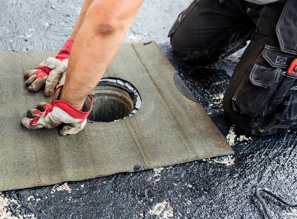 https://www.checkatrade.com/blog/wp-content/uploads/2024/12/flat-roof-replacement-drainage-hole.jpeg