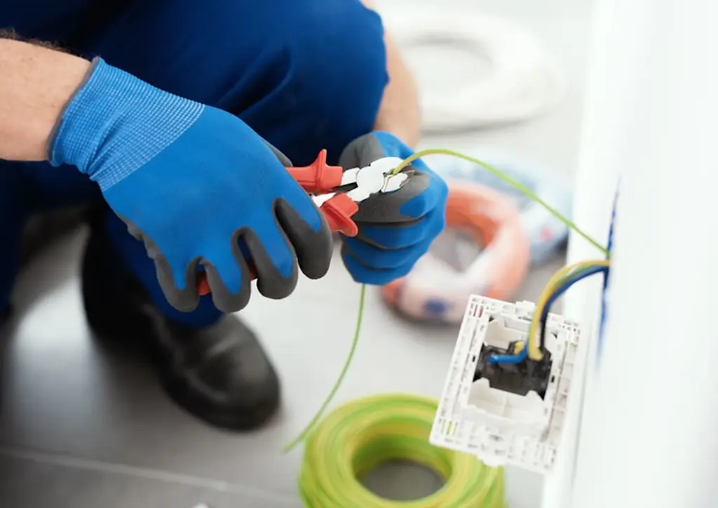 Electrician rewiring plug socket
