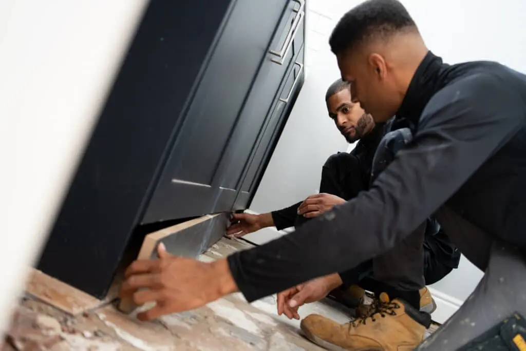 https://www.checkatrade.com/blog/wp-content/uploads/2024/11/Kitchen-installer-marketing-techniques-fitting-cupboard-1024x684.jpg