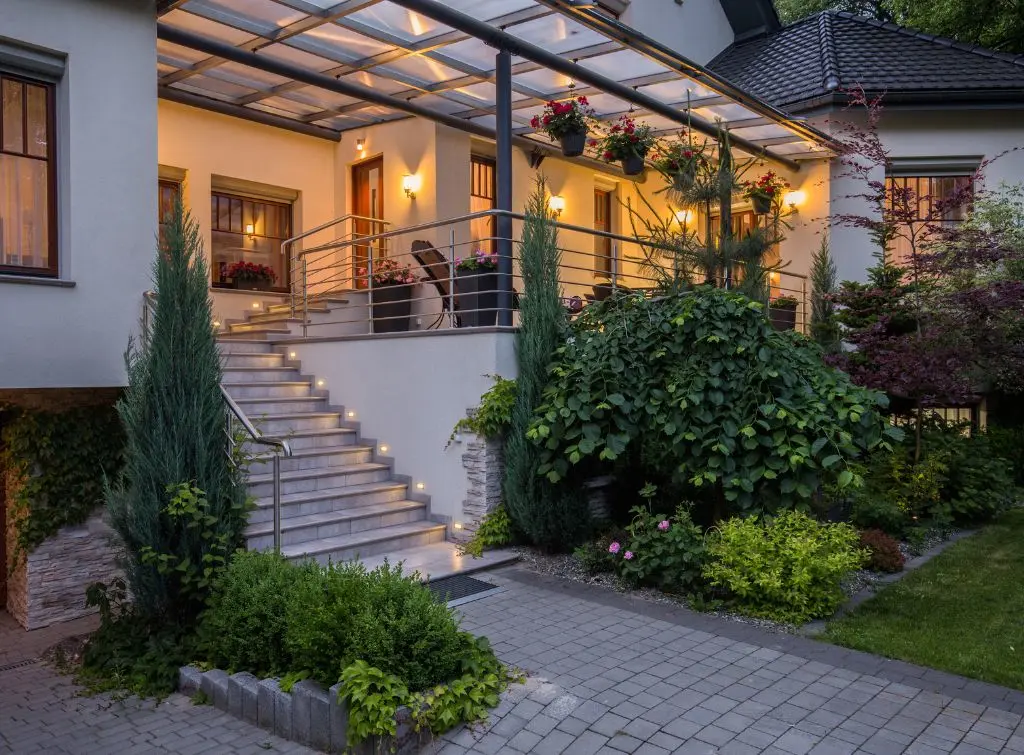A verandah in the evening with soft lights, plants, and seating