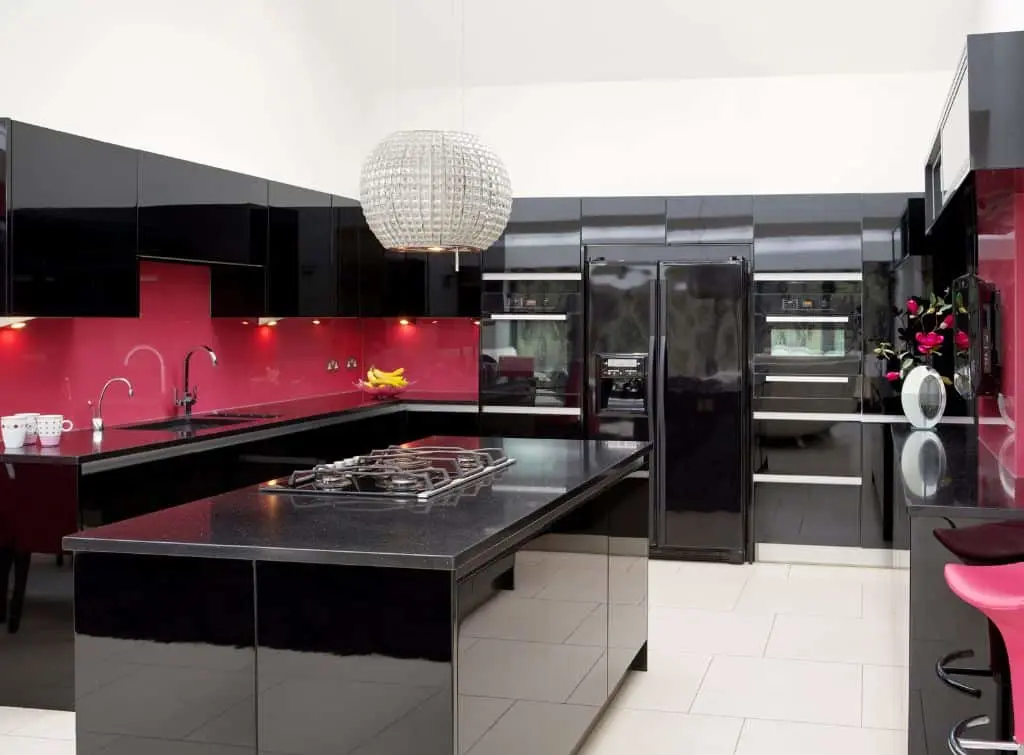 Hot pink kitchen with black countertops and a white ceiling