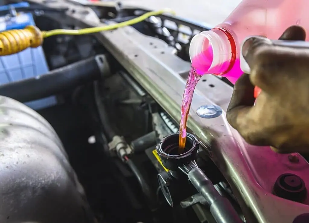 Coolant fluid being topped up in a car