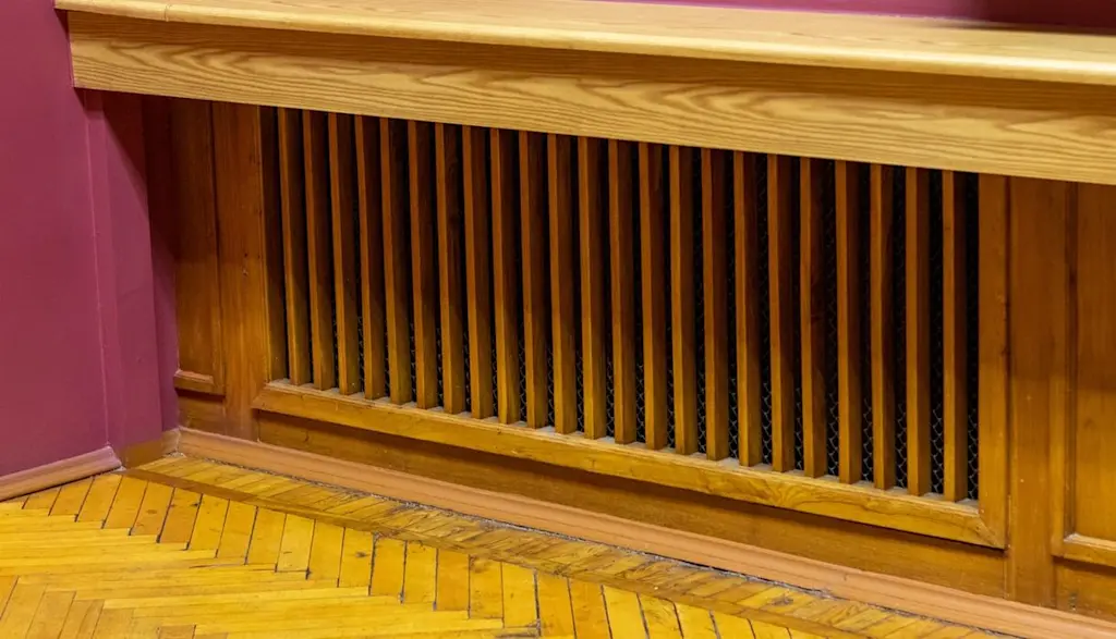 Wooden shelf above covered radiator