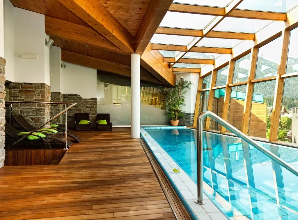 Indoor pool with glass roof and wooden rafters
