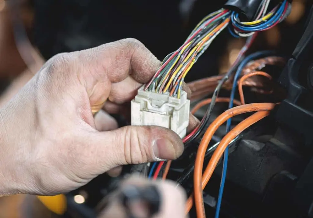 https://www.checkatrade.com/blog/wp-content/uploads/2024/06/auto-electrician-checking-car-wiring-1024x714.jpeg