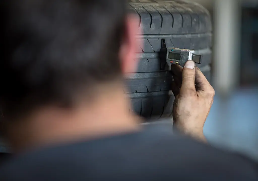 specialist checking tyre tread