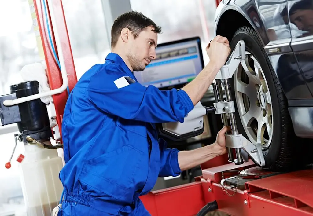 Mechanic aligning car wheel