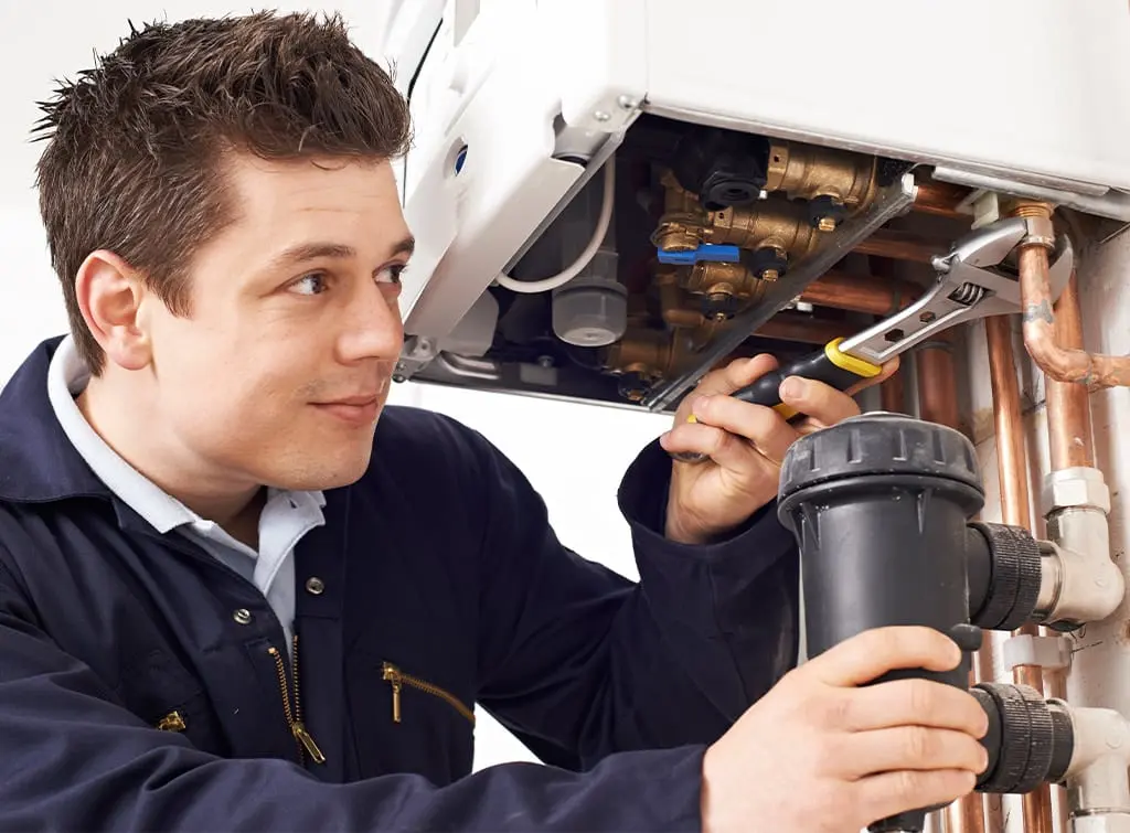 heating engineers inspects a boiler in a home