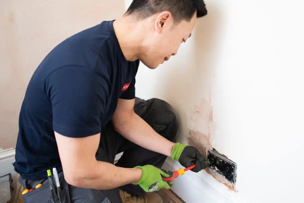 Electrician replacing sockets in a home