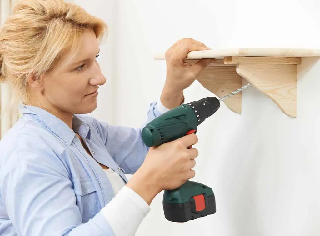 Handywoman putting up a shelf