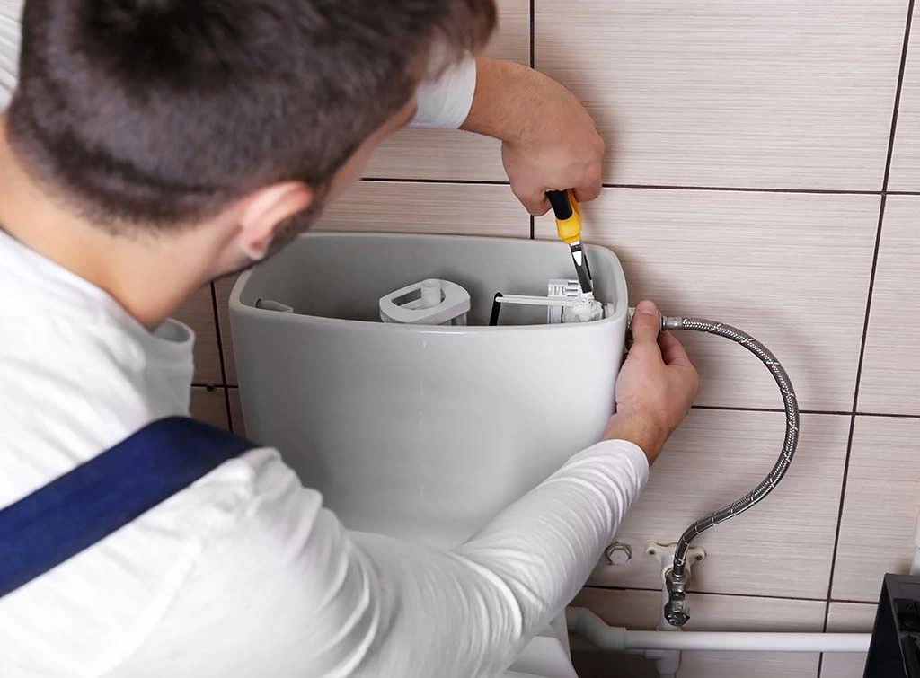 Plumber fixing toilet fills up with water then slowly drains