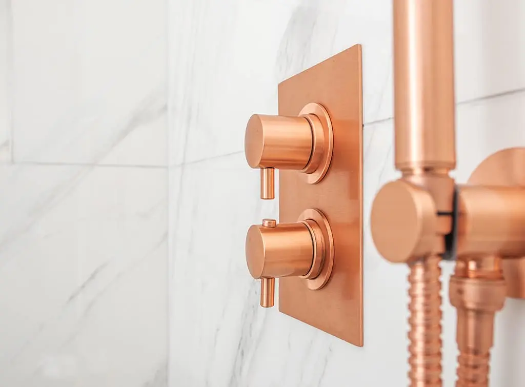 exposed copper valves on a mixer shower