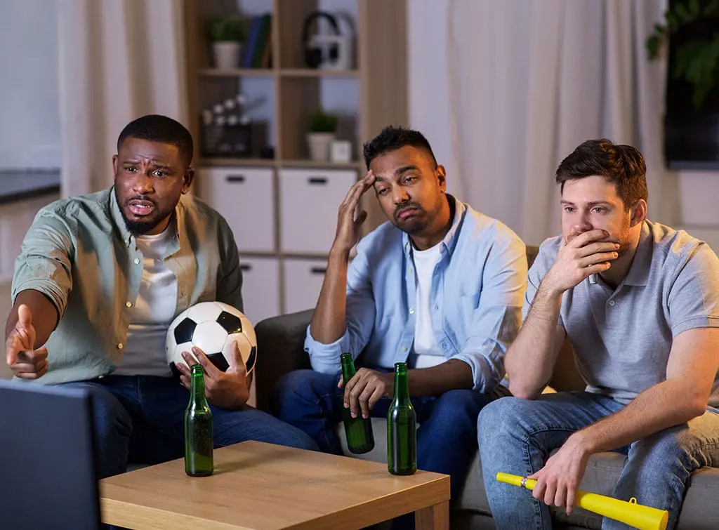 Football fans watching their team lose on TV