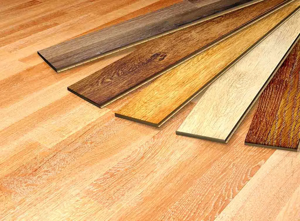 hardwood vs engineered wood cost - pictured are 5 planks of wood of differing colours on a light wooden floor
