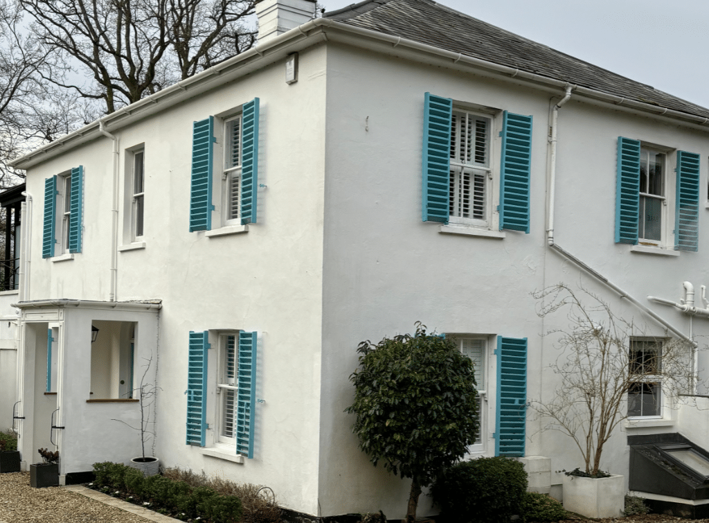 White rendered property and blue shutters