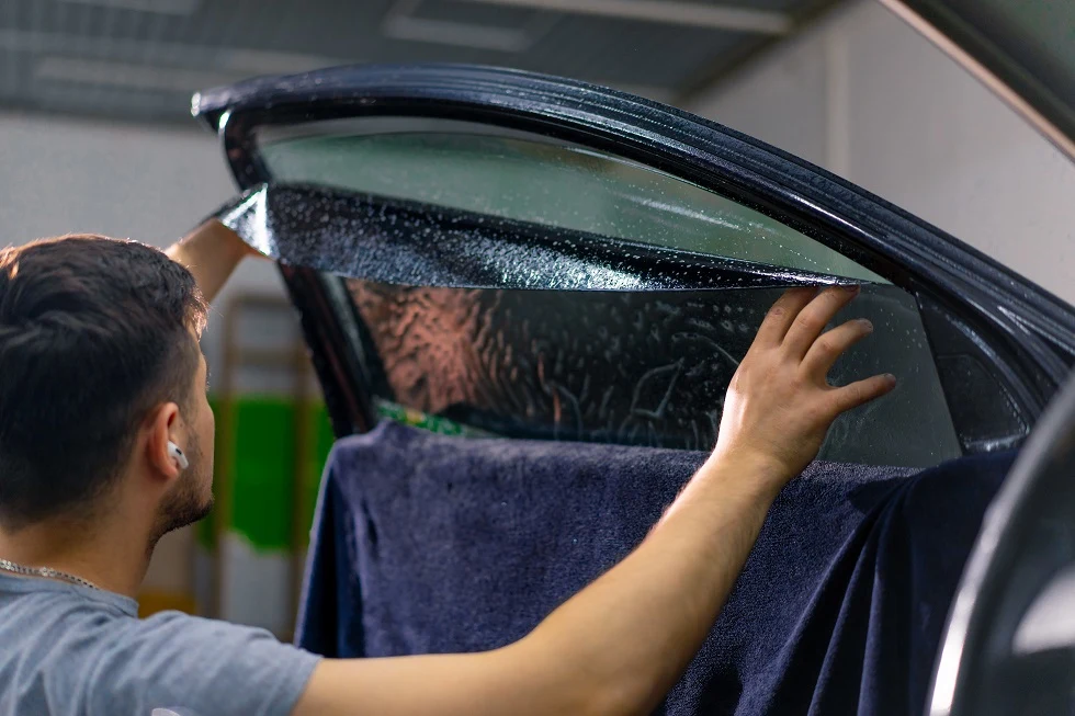 applying new car window tint