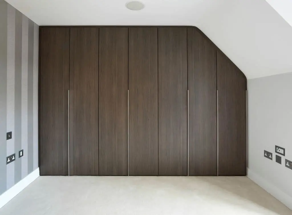 https://www.checkatrade.com/blog/wp-content/uploads/2024/02/Fitted-wardrobes-in-small-loft-bedroom.jpg