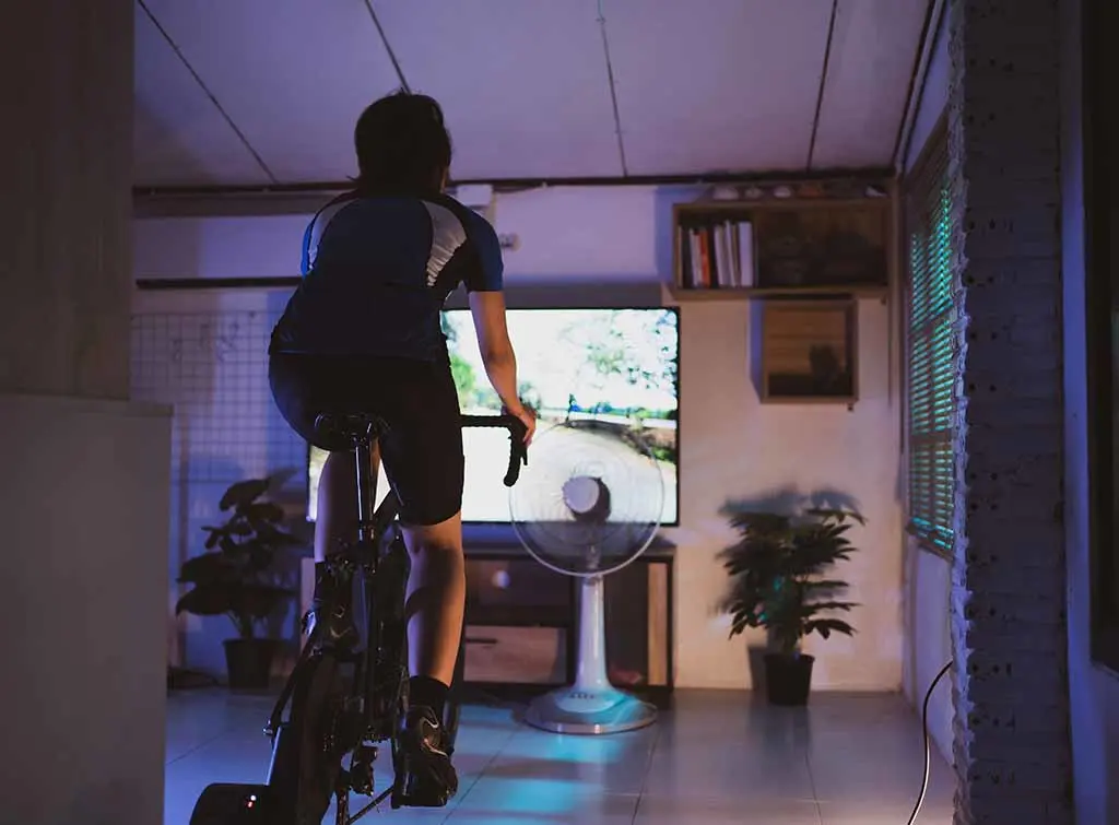 Indoor spin studio design idea - woman on static bike doing a workout