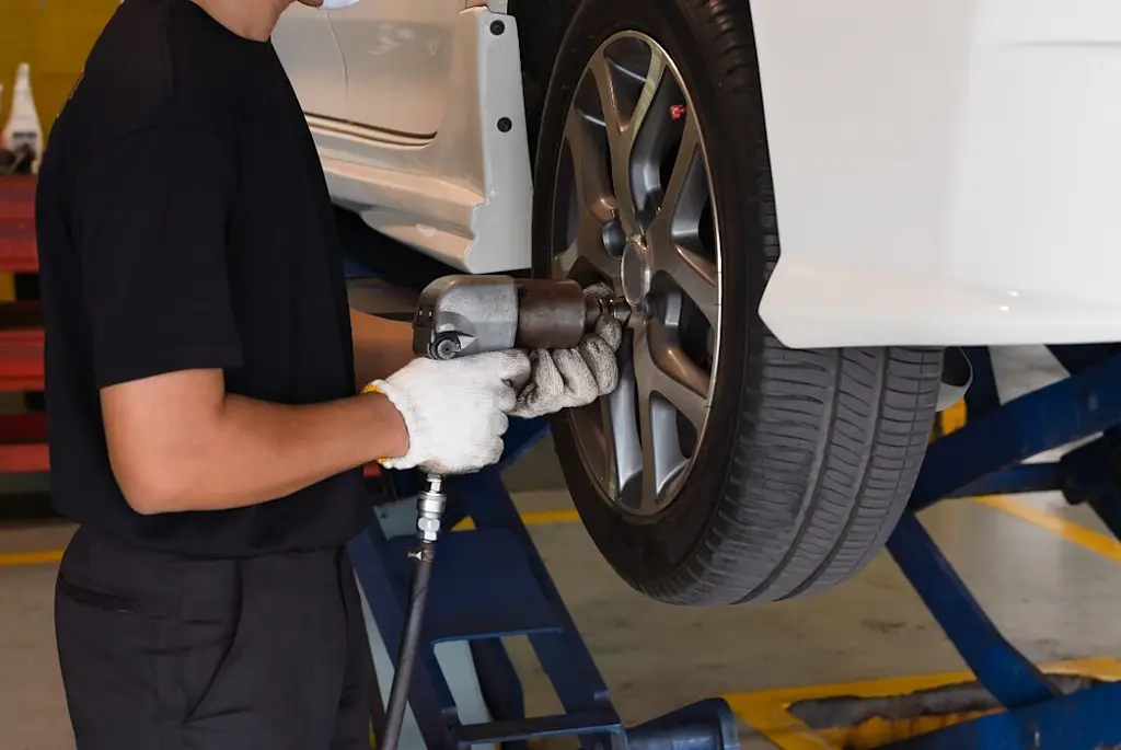 specialist changing tyre on car