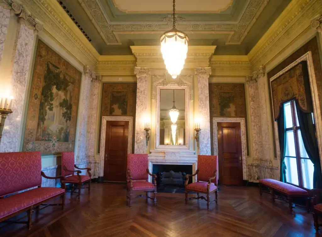 Classical art and coving for a Regencycore ballroom – red upholstery and tear drop chandelier