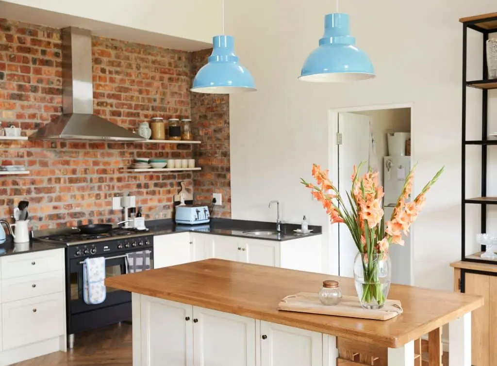 Brick feature wall with industrial style decor and a wooden kitchen island
