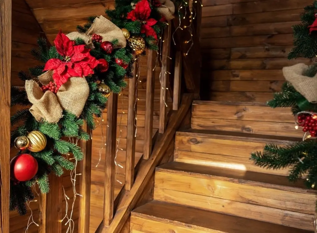 Wooden banister decorated in Xmas lights and wreaths