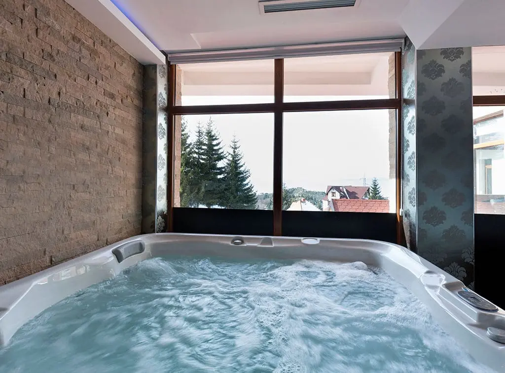 https://www.checkatrade.com/blog/wp-content/uploads/2021/12/hot-tub-installed-in-home.jpg