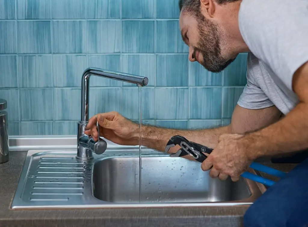 https://www.checkatrade.com/blog/wp-content/uploads/2024/08/plumber-working-on-tap-repair-for-kitchen.jpeg