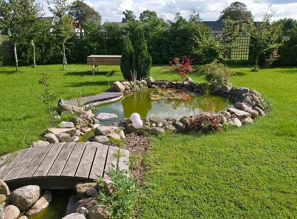 https://www.checkatrade.com/blog/wp-content/uploads/2021/04/Stone-and-wood-raised-pond.jpg
