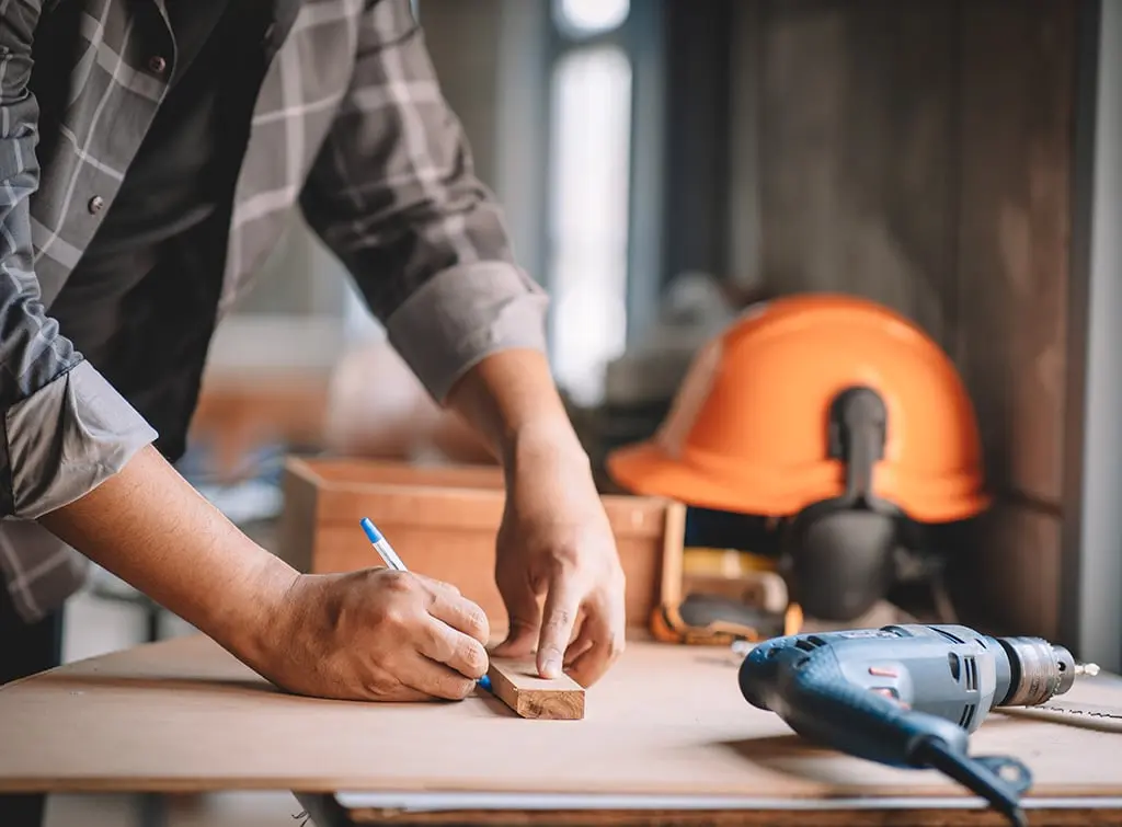 Builder with pencil using construction plant
