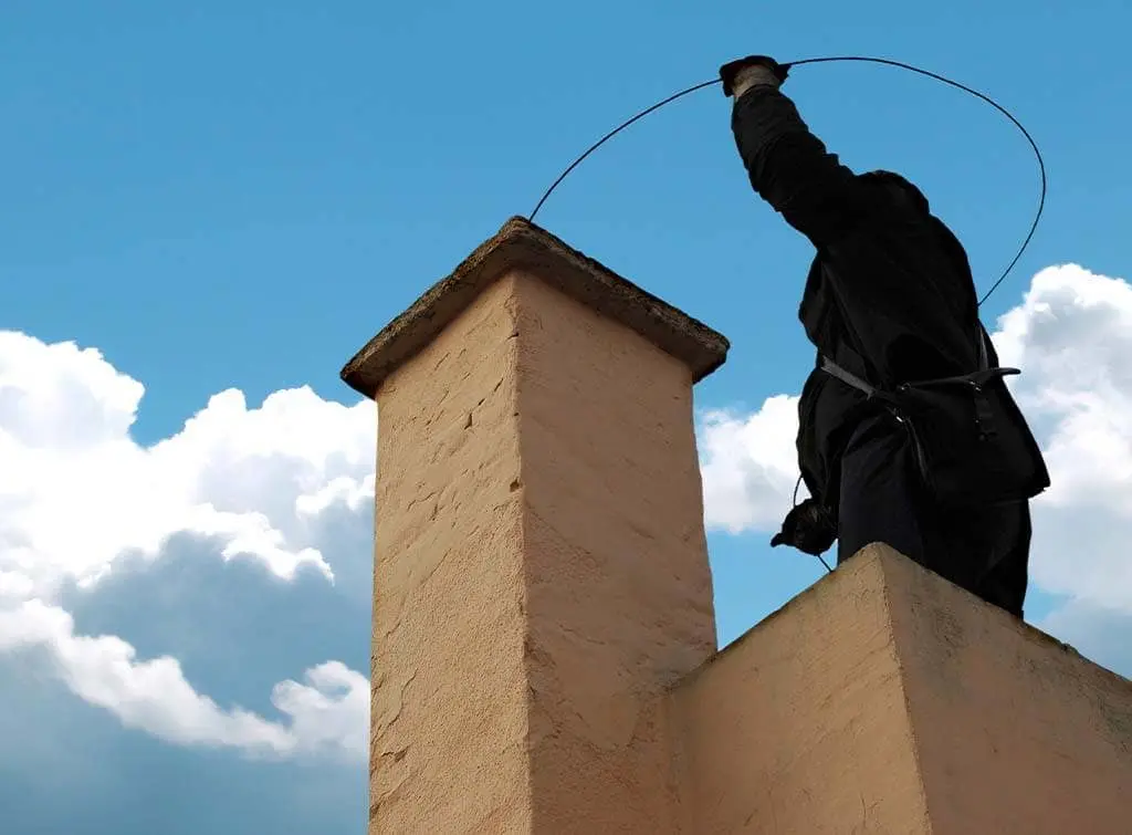 A chimney being cleaned by a sweeper