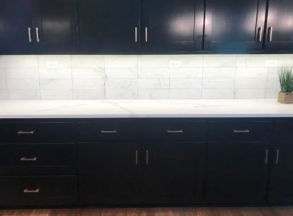 Dark blue cabinets and white splash back