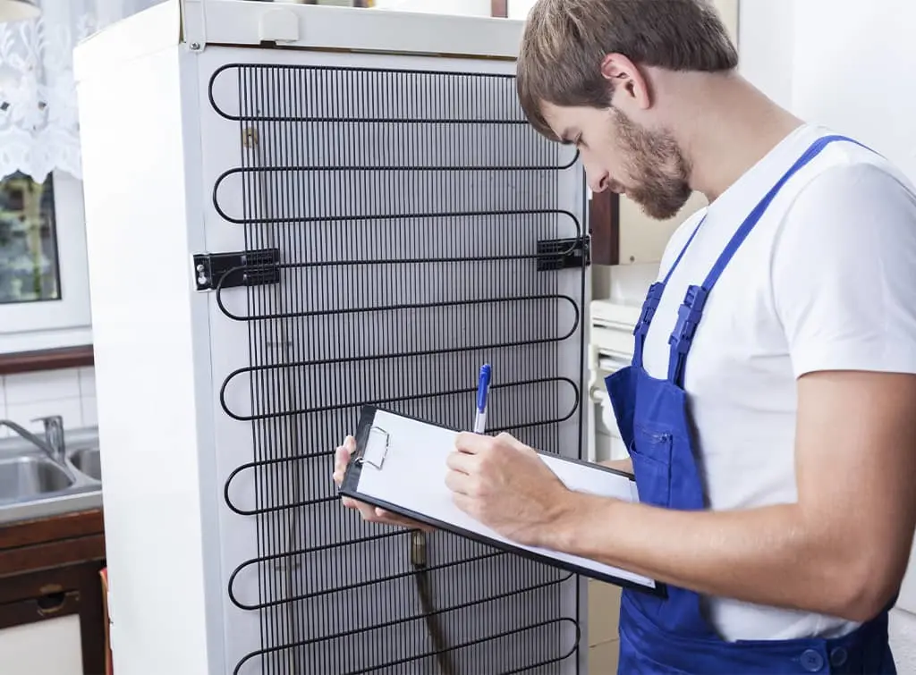 Domestic appliance engineer checking fridge freezer
