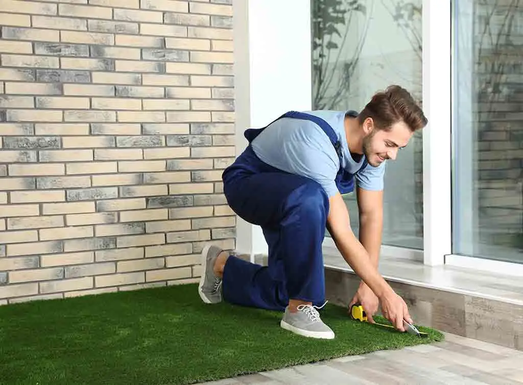 Artificial grass installer cuts turf to size