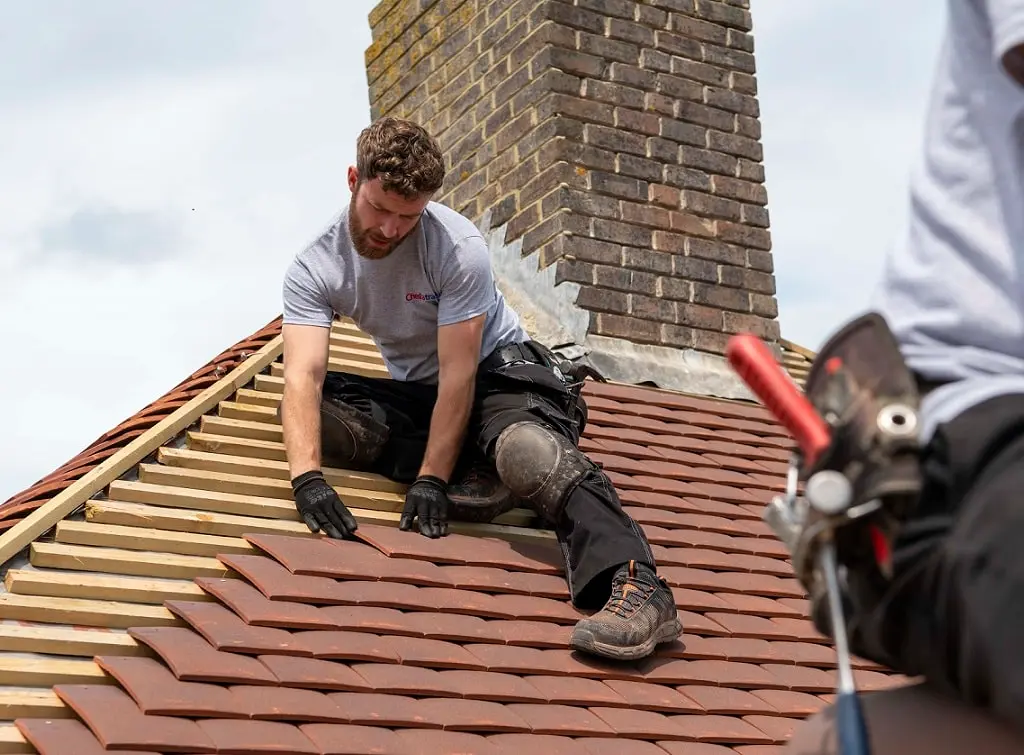 https://www.checkatrade.com/blog/wp-content/uploads/2024/08/roofer-working-on-replacing-tiles.jpg