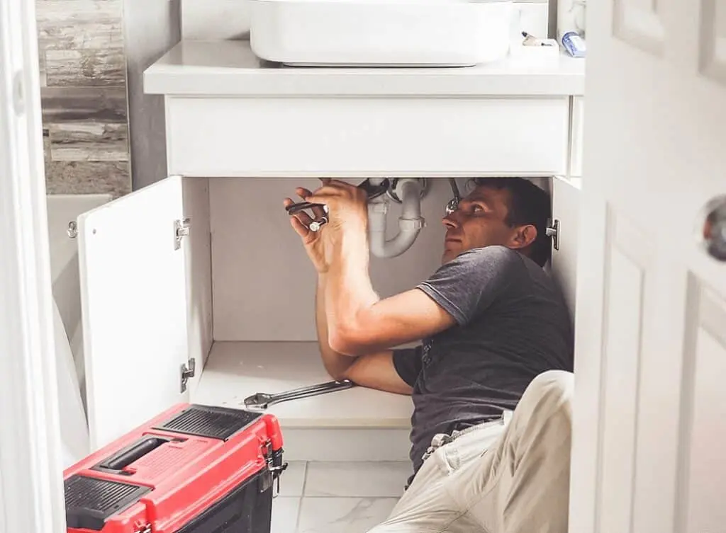 https://www.checkatrade.com/blog/wp-content/uploads/2024/08/plumber-fixing-a-kitchen-sink-1024x753.jpeg