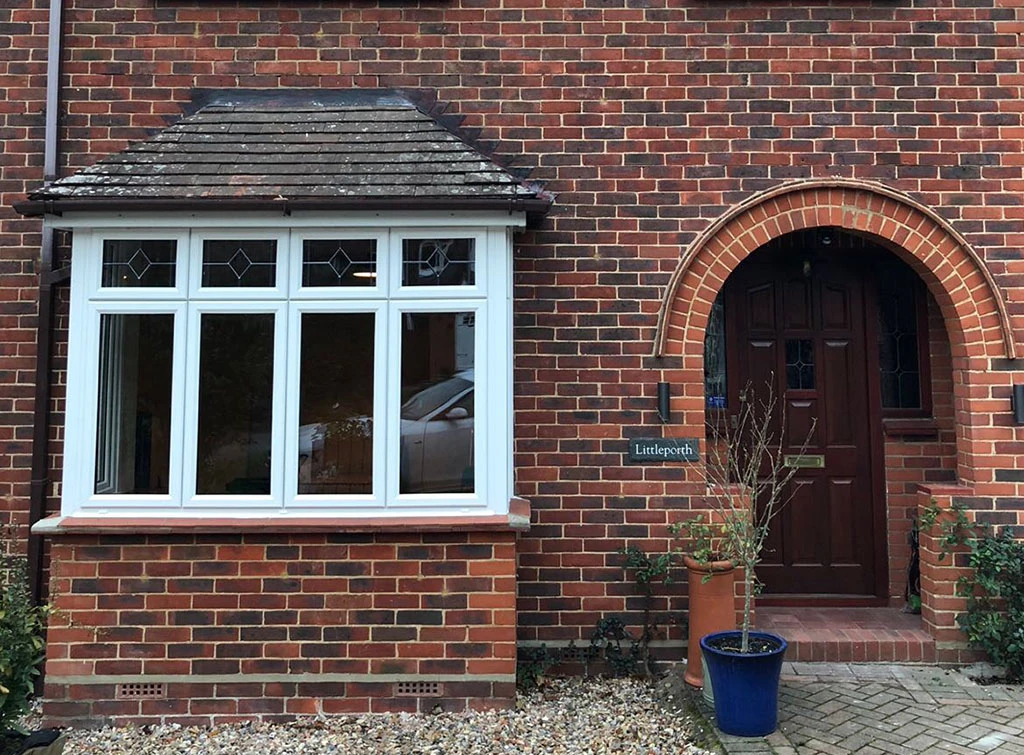 A tiled bay window roof on a red brick, 1930s house