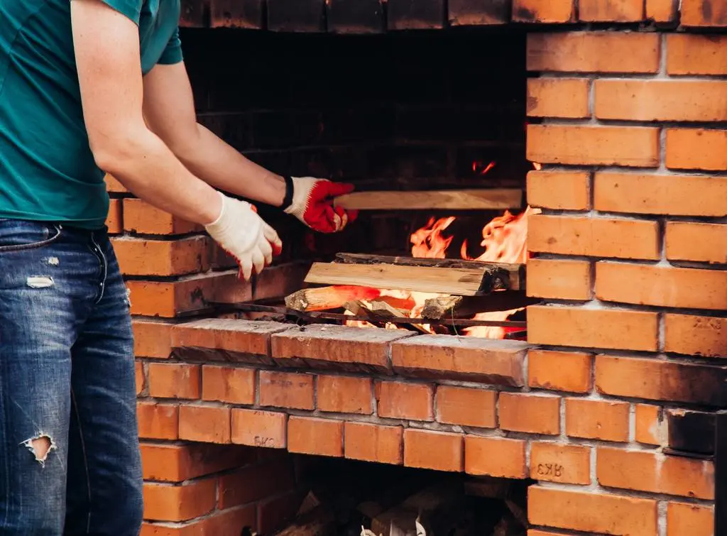 Man tending fire brick oven