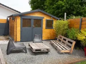 Building your perfect summer house: Lovely patio area with wood and black painted summer house with pitched roof