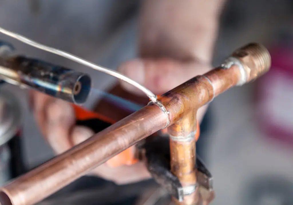 plumber-soldering-copper-pipe-tee-joint
