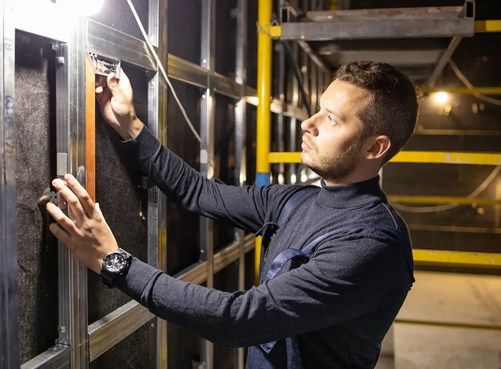 A tradesperson installing garage gym soundproofing for the home
